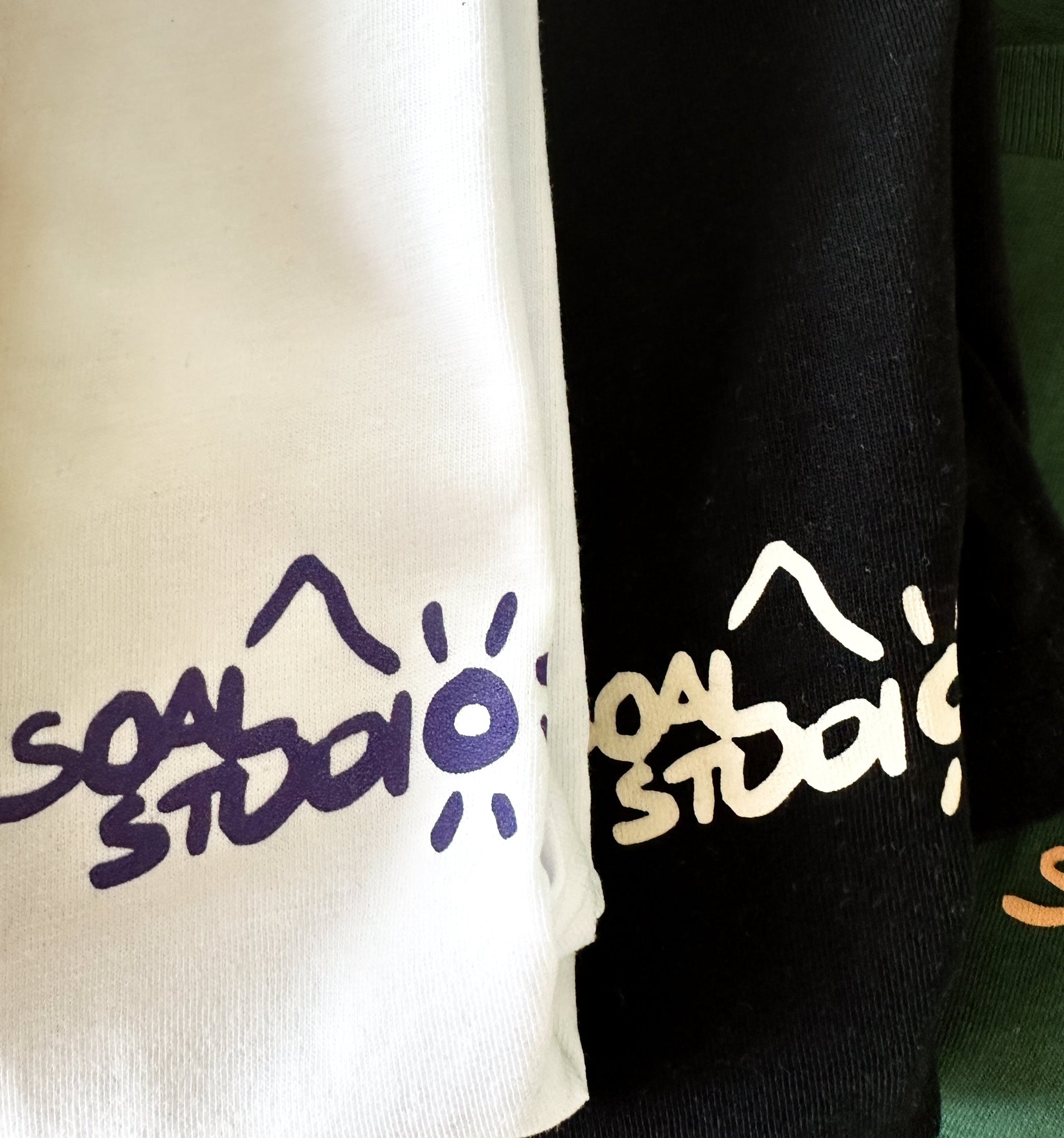 Two clothing items with 'SOAL STUDIO' branding in different colors. Here's white, black and green.